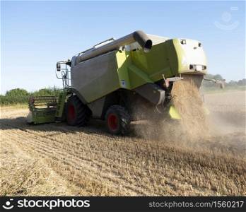 combine working on grain field during harvest in the north of france