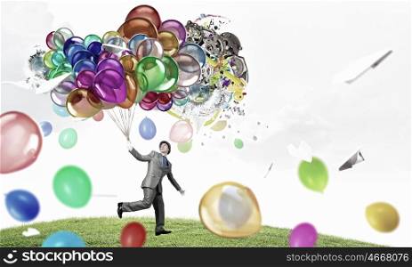 Comedian man with color balloons. Young funny man in hat with balloons presenting celebration concept. Elements of this image are furnished by NASA