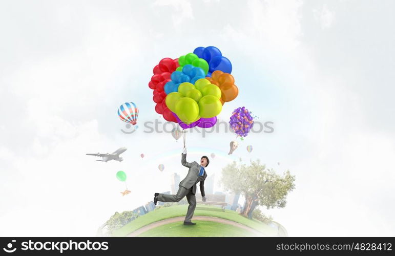 Comedian man with color balloons. Young funny man in hat with balloons presenting celebration concept