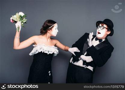 Comedy artists performing with flower bouquet. Mime theater performers posing. Pantomime actor and actress
