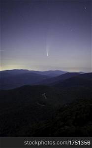 Comet Neowise rising over Skyline Drive in Shenandoah National Park, Virginia as the mountain range is softly lit by moonlight.