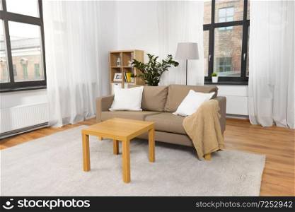 comfort, furniture and interior concept - tidy living room with cushioned sofa and table at home. interior of home living room with sofa and table