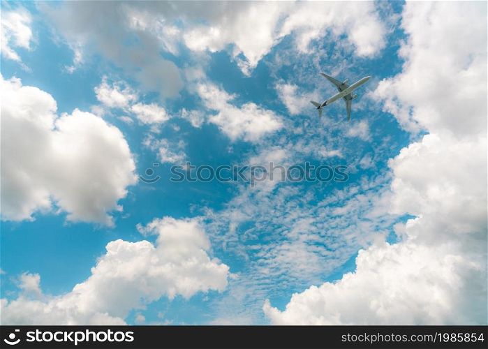 Commercial airline flying on blue sky and white cumulus clouds. Under view airplane flying. Passenger plane travel bubble flight. Vacation travel abroad after coronavirus crisis. Air transportation.