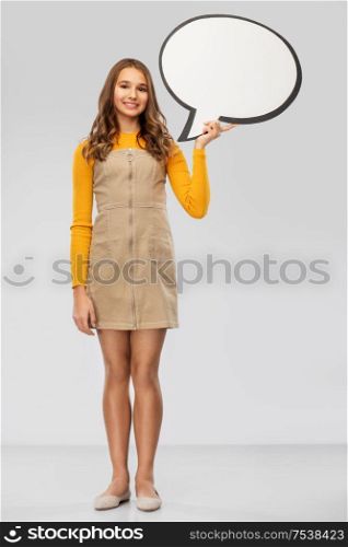 communication and people concept - smiling teenage girl holding blank speech bubble over grey background. teenage girl holding speech bubble