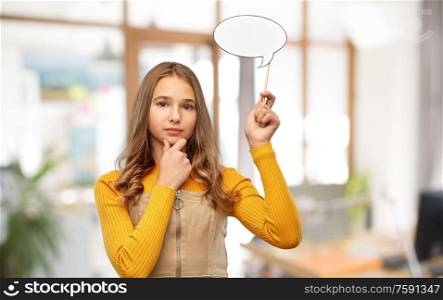 communication and people concept - smiling teenage student girl holding blank speech bubble over office background. teenage girl holding speech bubble over office