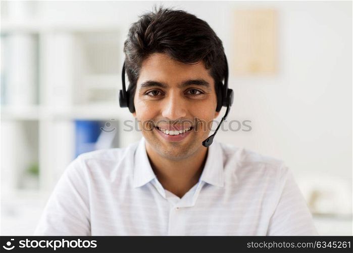 communication, business, people and technology concept - businessman or helpline operator in headset at office. businessman in headset at office