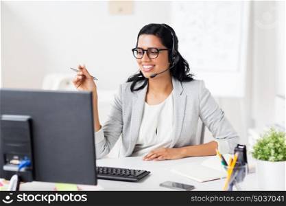 communication, business, people and technology concept - smiling businesswoman or helpline operator with headset and computer at office. businesswoman with headset and computer at office