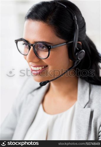 communication, business, people and technology concept - smiling businesswoman or helpline operator with headset talking at office. businesswoman with headset talking at office