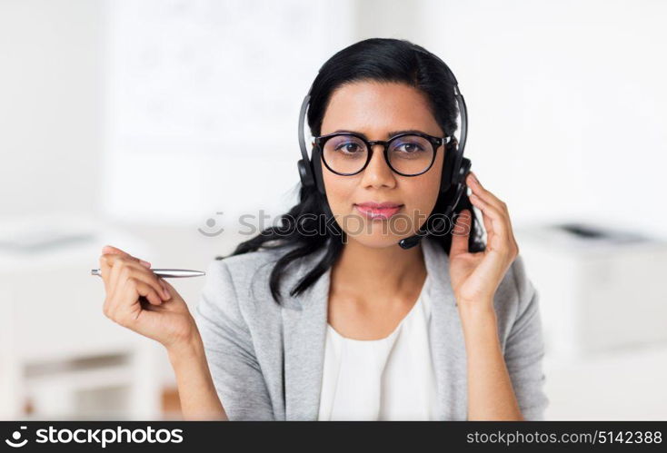 communication, business, people and technology concept - smiling businesswoman or helpline operator with headset talking at office. businesswoman with headset talking at office