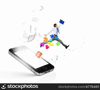 Communication concept. Image of businessman jumping out of mobile phone