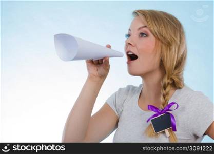Communication concept. Young blonde woman talking loud through megaphone made of paper.. Woman screaming through megaphone made of paper