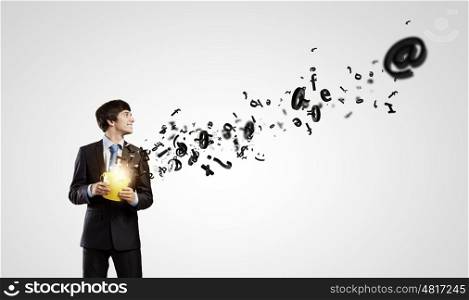 Communication concept. Young businessman holding yellow bucket with flying out symbols