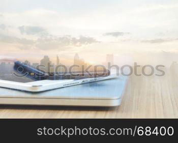 communication device stack on desk and city background reflect modern technology concept