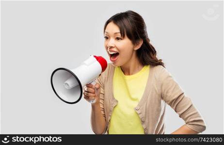 communication, feminism and human rights concept - asian young woman speaking to megaphone over grey background. asian woman speaking to megaphone