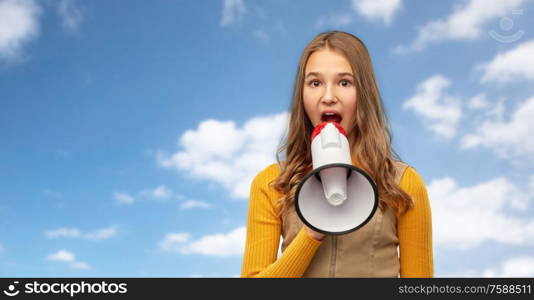 communication, feminism and human rights concept - teenage girl speaking to megaphone over blue sky and clouds background. teenage girl speaking to megaphone