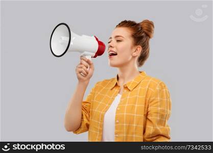 communication, feminism and rights concept - red haired teenage girl in checkered shirt speaking to megaphone over grey background. red haired teenage girl speaking to megaphone