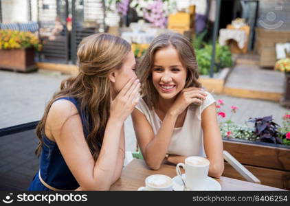 communication, friendship and people concept - happy young women drinking coffee at outdoor cafe. happy young women drinking coffee at outdoor cafe