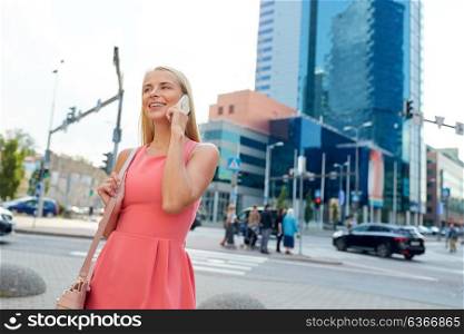 communication, lifestyle and people concept - happy smiling young woman with bag calling on smartphone on city street. happy smiling woman calling on smartphone in city