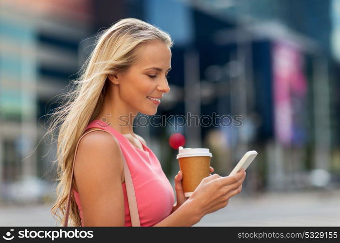 communication, technology and people concept - happy smiling young woman with coffee and smartphone on city street. woman with coffee and smartphone in city