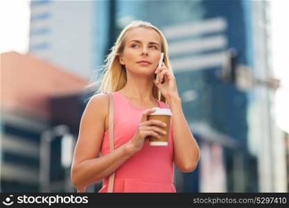 communication, technology and people concept - young woman with coffee calling on smartphone on city street. woman with coffee calling on smartphone in city