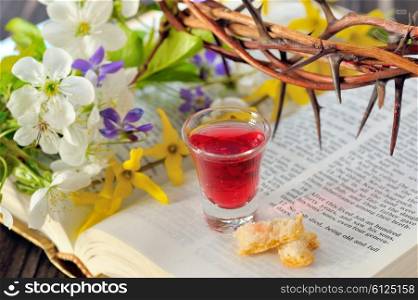 Communion cup with wine and bread on bible