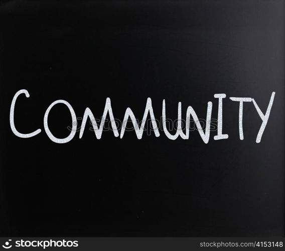 ""Community" handwritten with white chalk on a blackboard"