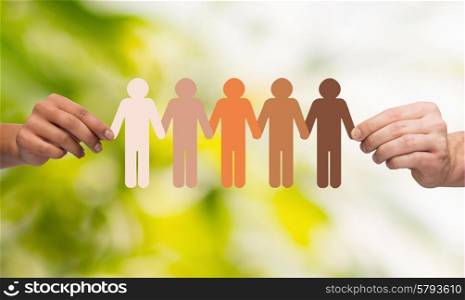 community, unity, people and support concept - couple hands holding paper chain multiracial people over green background