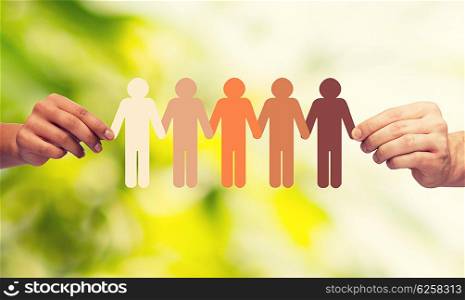 community, unity, people and support concept - couple hands holding paper chain multiracial people over green background