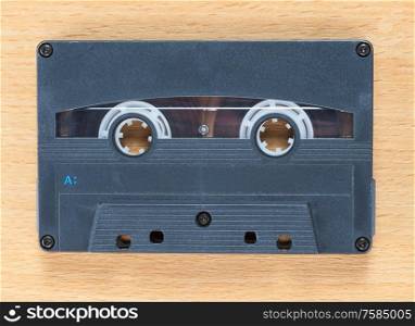 Compact audio cassette tape on a wooden background