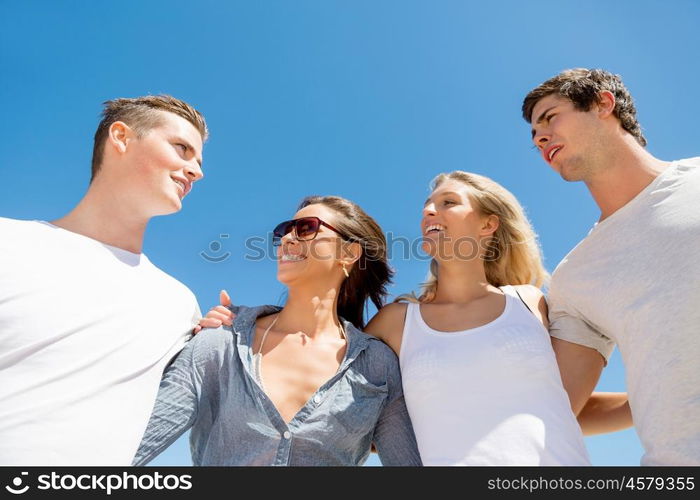 Company of young people on the beach. Company of young friends on the beach walking along the shore