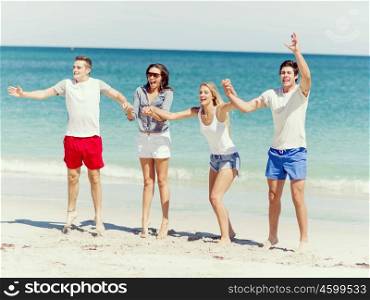 Company of young people on the beach. Company of young friends on the beach having fun jumping