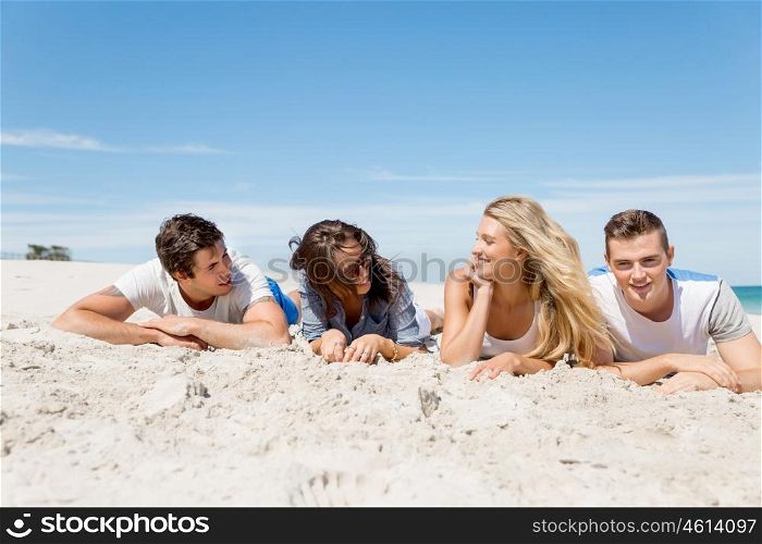 Company of young people on the beach. Company of young friends on the beach relaxing on white sand