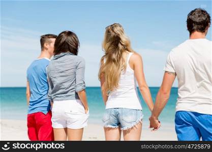 Company of young people on the beach. Company of young friends on the beach standing and looking at ocean