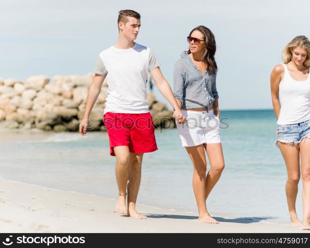 Company of young people on the beach. Company of young friends on the beach walking along the shore