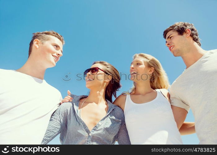 Company of young people on the beach. Company of young friends on the beach walking along the shore