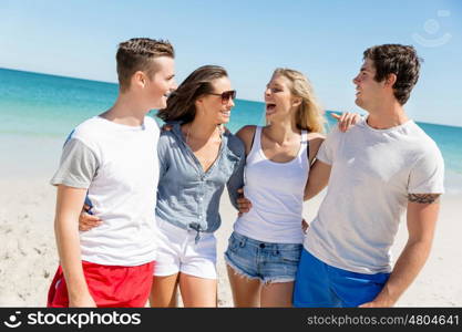 Company of young people on the beach. Company of young friends on the beach walking along the shore