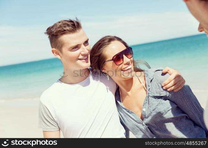 Company of young people on the beach. Company of young friends on the beach walking along the shore