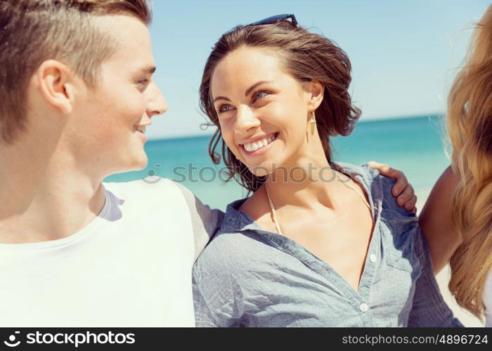 Company of young people on the beach. Company of young friends on the beach walking along the shore