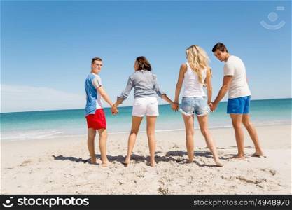 Company of young people on the beach. Company of young friends on the beach walking along the shore
