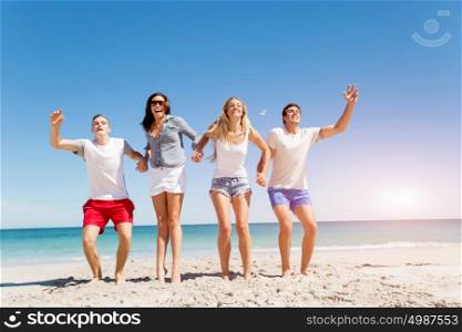 Company of young people on the beach. Company of young friends on the beach having fun jumping