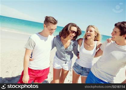 Company of young people on the beach. Company of young friends on the beach walking along the shore