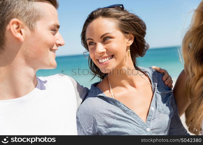 Company of young people on the beach. Company of young friends on the beach walking along the shore