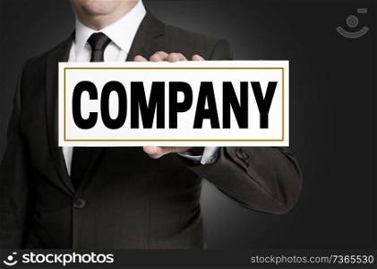 Company sign is held by businessman.. Company sign is held by businessman
