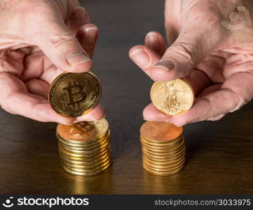 Comparison between gold and bitcoin as an investment. Senior man holding gold coins alongside stack of bitcoins to illustrate investment choice. Comparison between gold and bitcoin as an investment