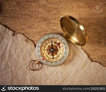 compass and a piece of old paper on a wooden board
