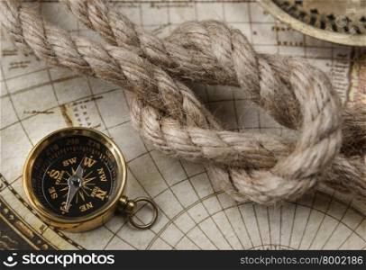 Compass and marine knot located on the background of old map