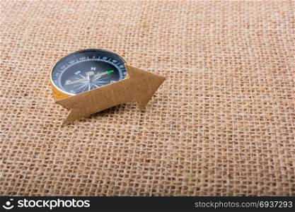 Compass and paper arrow on a canvas background