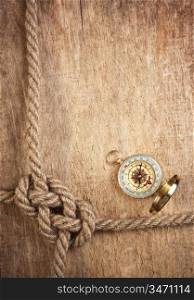 compass and rope knot on a wooden background