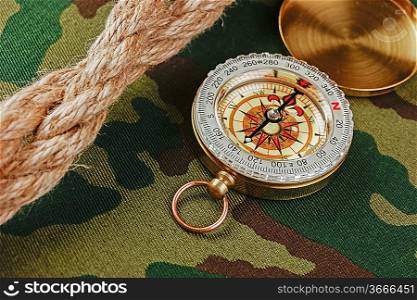 Compass and rope on a camouflage background