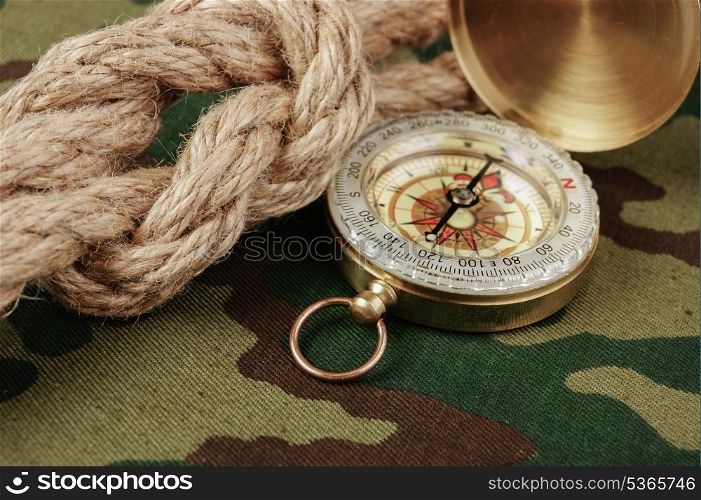 Compass and rope on a camouflage background